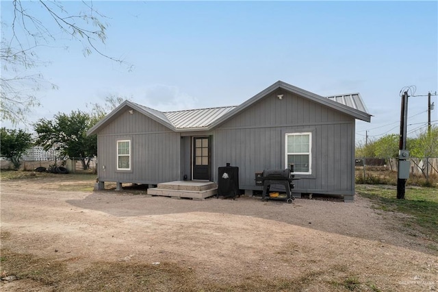 back of property with fence and metal roof