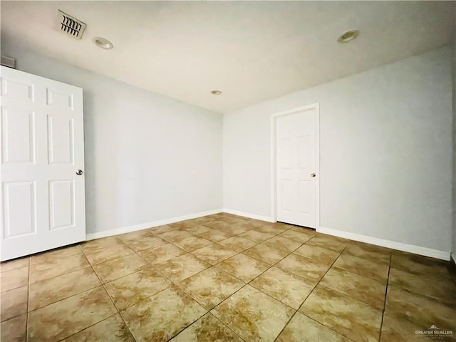 empty room with visible vents, baseboards, and tile patterned floors