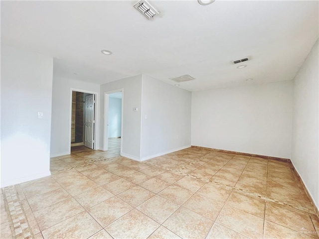 spare room with light tile patterned floors, baseboards, and visible vents