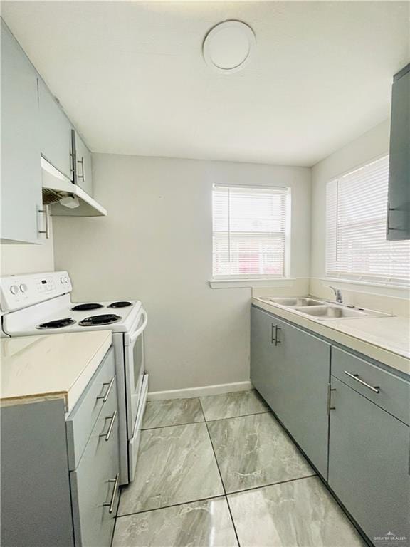 kitchen featuring white electric range oven, gray cabinets, light countertops, under cabinet range hood, and a sink