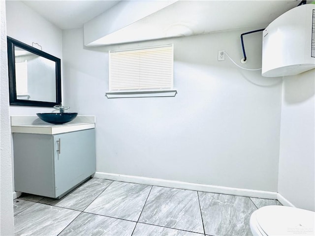 bathroom with toilet, baseboards, and vanity