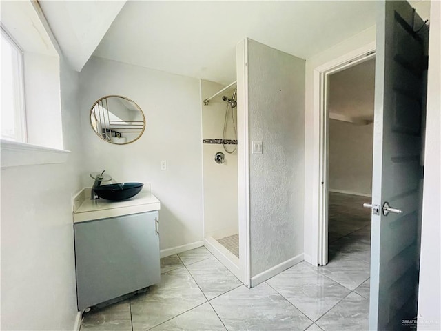 full bath featuring baseboards, a shower stall, and vanity