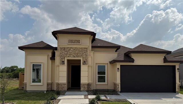 prairie-style house featuring a front lawn and a garage