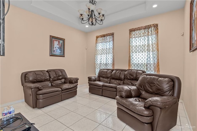 tiled living room featuring a raised ceiling and a chandelier