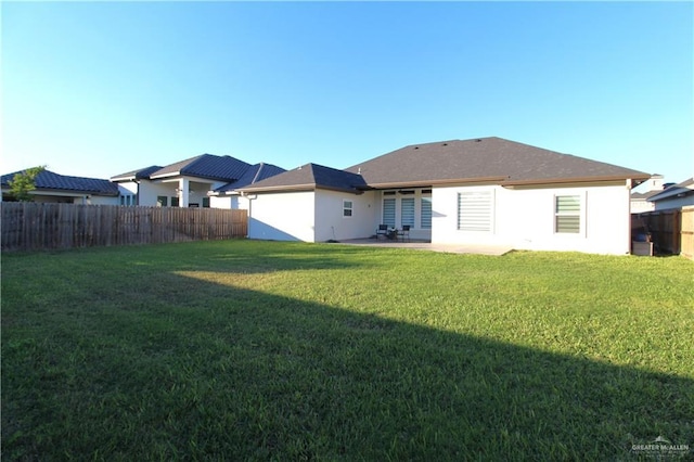 rear view of property with a yard and a patio