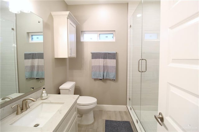 bathroom with vanity, a wealth of natural light, toilet, and a shower with shower door