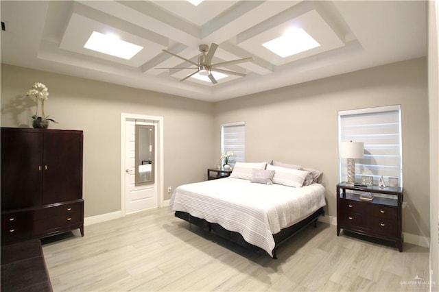 bedroom featuring beam ceiling, ceiling fan, coffered ceiling, and light hardwood / wood-style floors