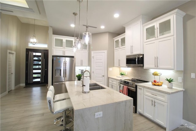 kitchen featuring white cabinetry, an island with sink, and appliances with stainless steel finishes