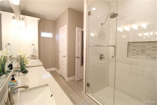 bathroom with walk in shower, vanity, and hardwood / wood-style flooring