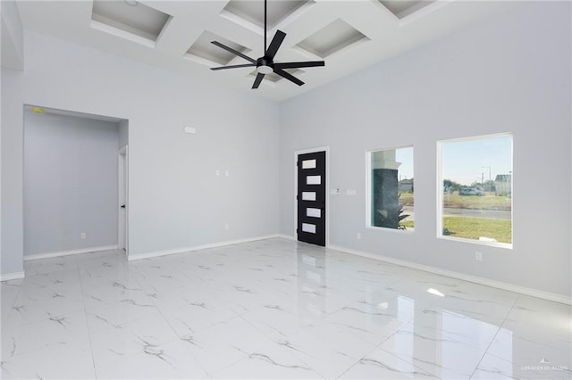 empty room featuring ceiling fan, beam ceiling, a towering ceiling, and coffered ceiling