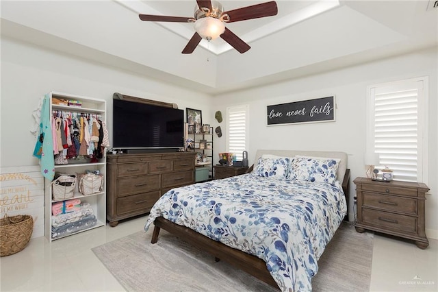 bedroom featuring ceiling fan and a tray ceiling