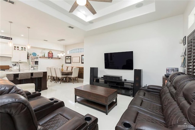 living room featuring a tray ceiling and ceiling fan