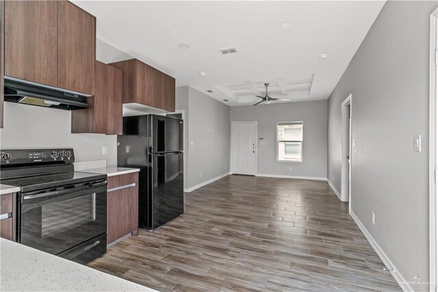 kitchen with black appliances, ceiling fan, light hardwood / wood-style floors, and exhaust hood