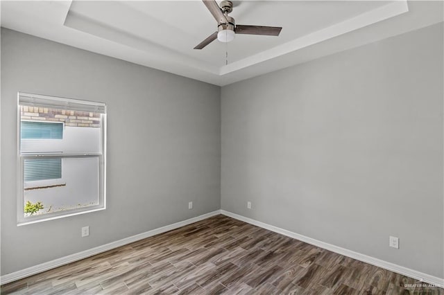 spare room featuring hardwood / wood-style floors and a raised ceiling