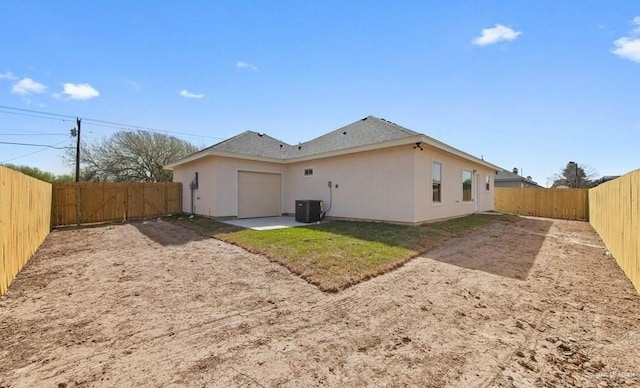 426 N Parker Rd, La Feria, TX 78559 - back of house with stucco siding, an attached garage, a fenced backyard, central AC, and driveway