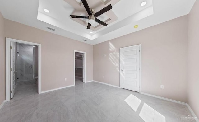 unfurnished bedroom with recessed lighting, a spacious closet, baseboards, a raised ceiling, and visible vents