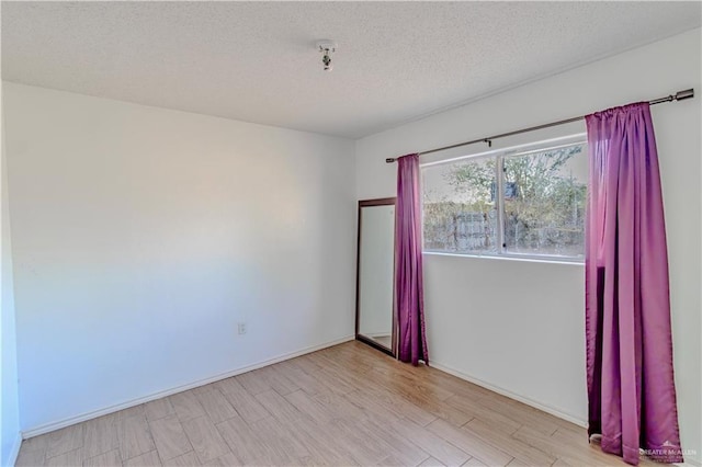 2800 Del Oro Dr, Mission, TX 78572 - empty room featuring baseboards, a textured ceiling, and wood finished floors