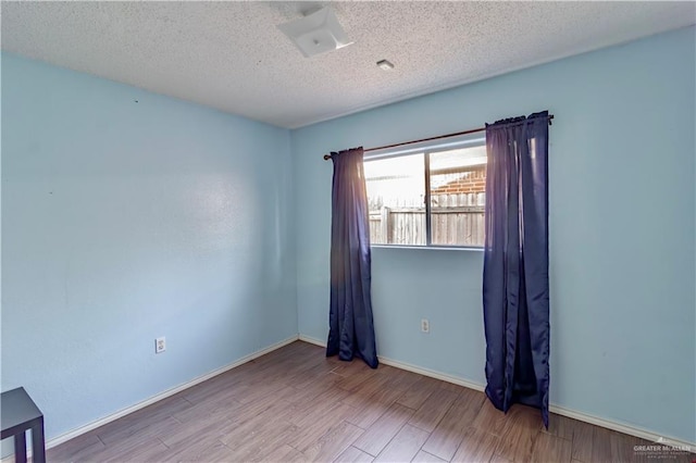 2800 Del Oro Dr, Mission, TX 78572 - empty room featuring baseboards, a textured ceiling, and wood finished floors