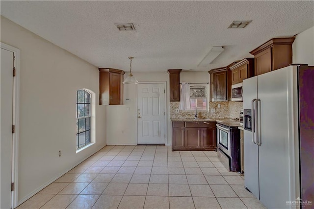 2800 Del Oro Dr, Mission, TX 78572 - kitchen featuring a sink, tasteful backsplash, appliances with stainless steel finishes, light tile patterned floors, and visible vents
