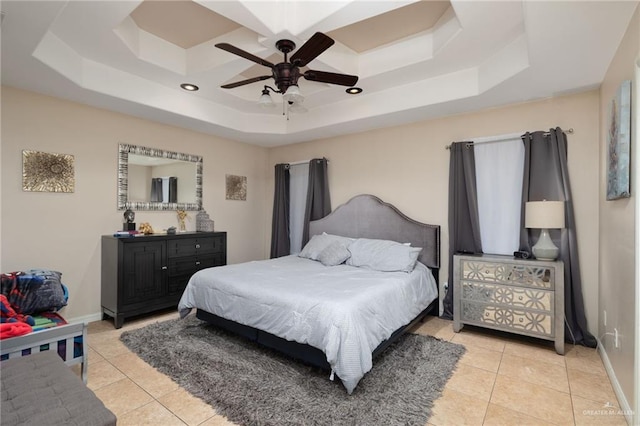 bedroom featuring ceiling fan, a raised ceiling, and light tile patterned floors