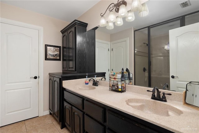 bathroom with tile patterned floors, a shower with door, vanity, and a chandelier