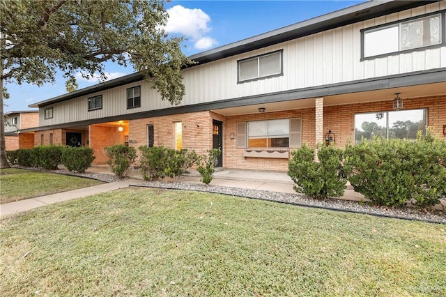 townhome / multi-family property with covered porch and a front yard