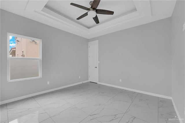 unfurnished room featuring a raised ceiling and ceiling fan