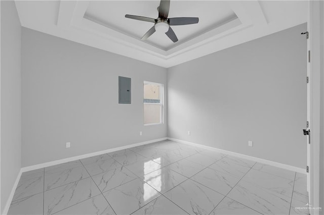 empty room featuring a raised ceiling, electric panel, and ceiling fan