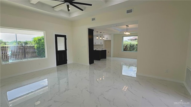 unfurnished room featuring ceiling fan and a raised ceiling