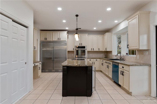 kitchen with sink, a kitchen island, pendant lighting, light tile patterned flooring, and appliances with stainless steel finishes