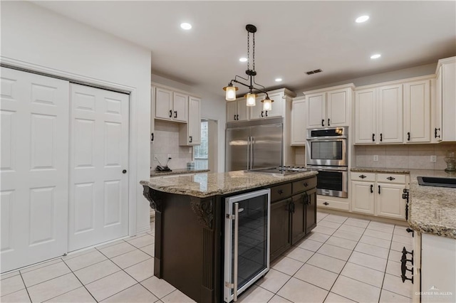 kitchen with a center island, beverage cooler, decorative light fixtures, decorative backsplash, and appliances with stainless steel finishes