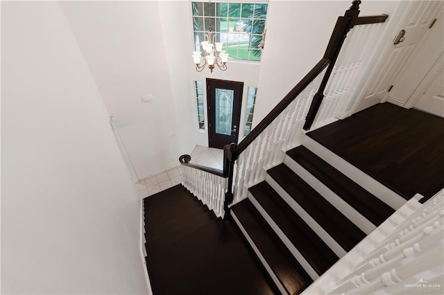 staircase with a notable chandelier