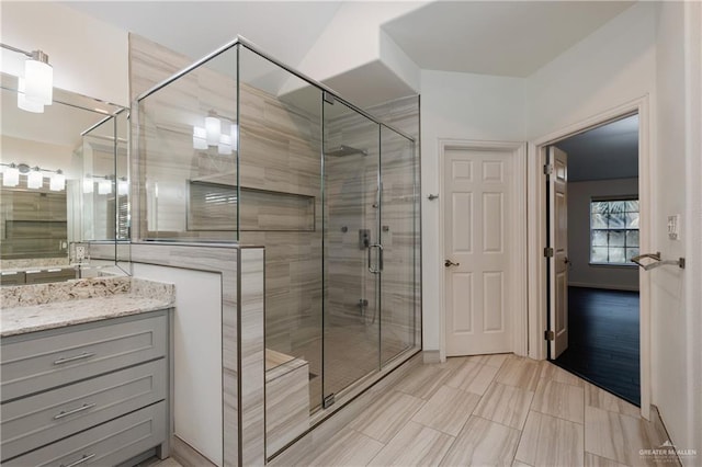 bathroom featuring hardwood / wood-style floors, vanity, and a shower with door