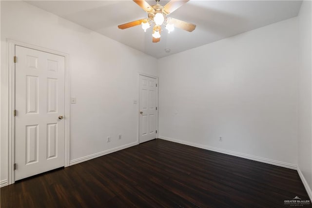 spare room with dark hardwood / wood-style floors and ceiling fan