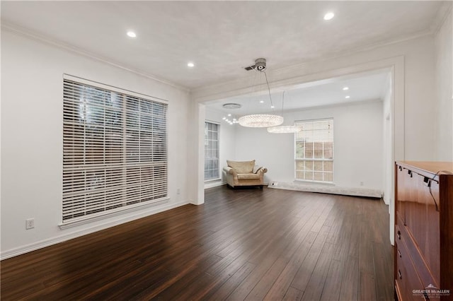 interior space featuring a chandelier, dark wood-type flooring, and ornamental molding