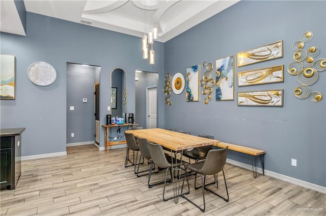 dining area featuring light hardwood / wood-style floors and a tray ceiling