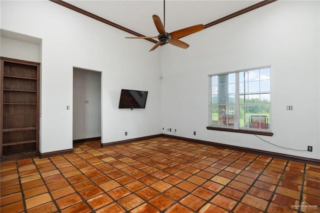 unfurnished bedroom with ceiling fan, tile patterned flooring, and a towering ceiling