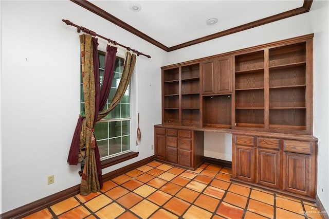 unfurnished office with built in desk, crown molding, and light tile patterned floors