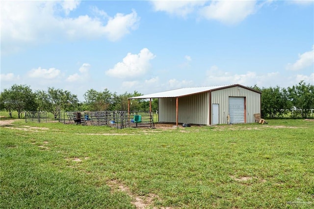 view of outbuilding with a lawn and a rural view