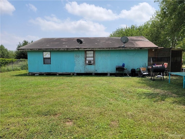 rear view of house with a lawn, cooling unit, and a trampoline