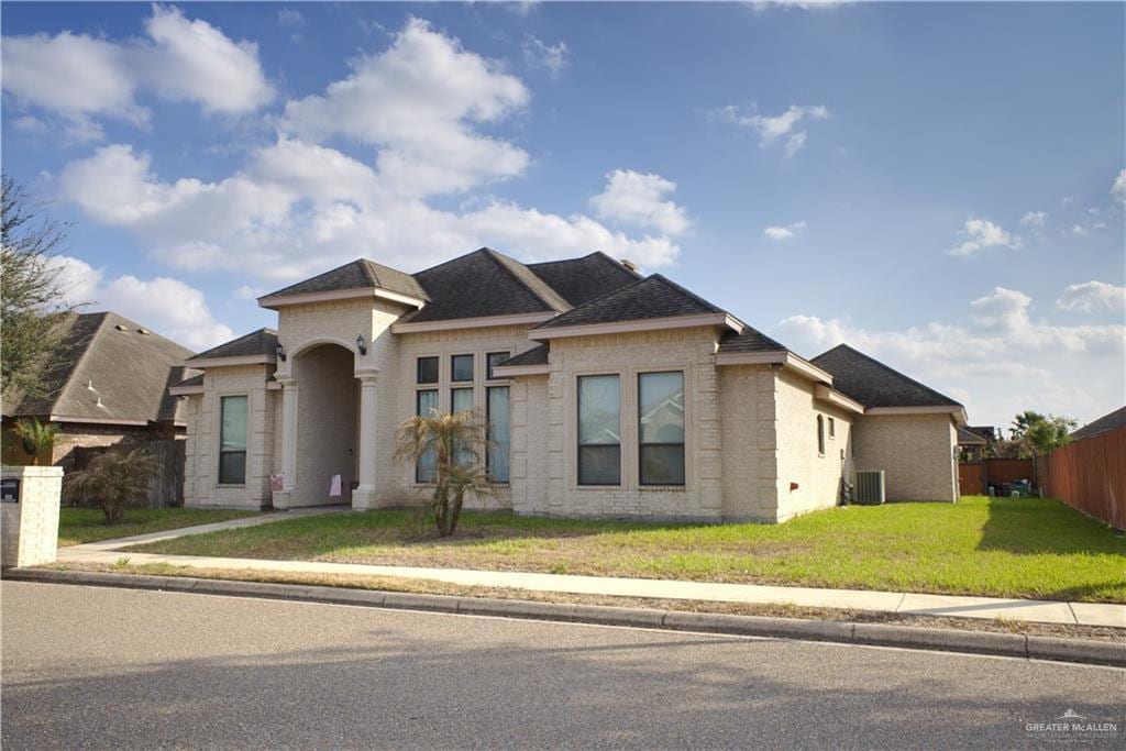 prairie-style home featuring a front yard and central air condition unit