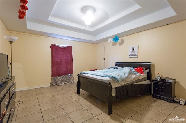 bedroom featuring a tray ceiling and light tile patterned flooring