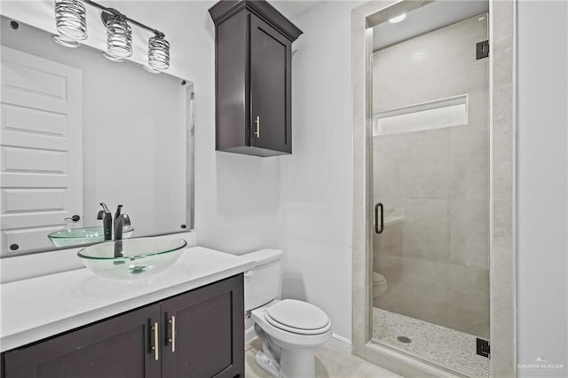 bathroom with a shower with door, vanity, and toilet