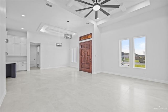 unfurnished living room with ceiling fan and a high ceiling