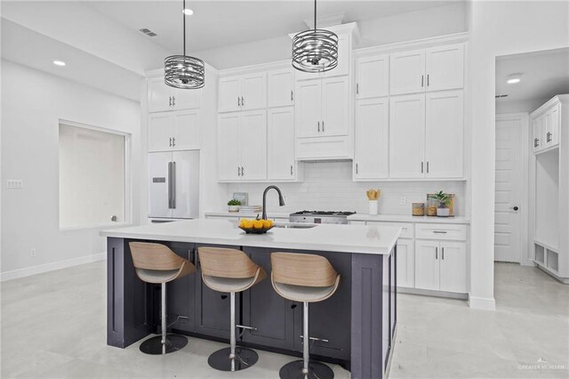 kitchen featuring a sink, tasteful backsplash, white cabinetry, built in fridge, and light countertops