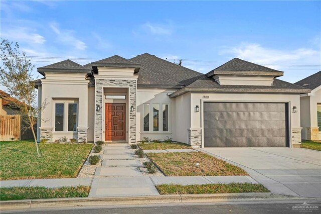 prairie-style home with a garage and a front lawn