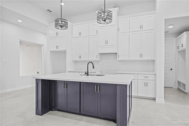 kitchen featuring white cabinetry, sink, pendant lighting, and a kitchen island with sink