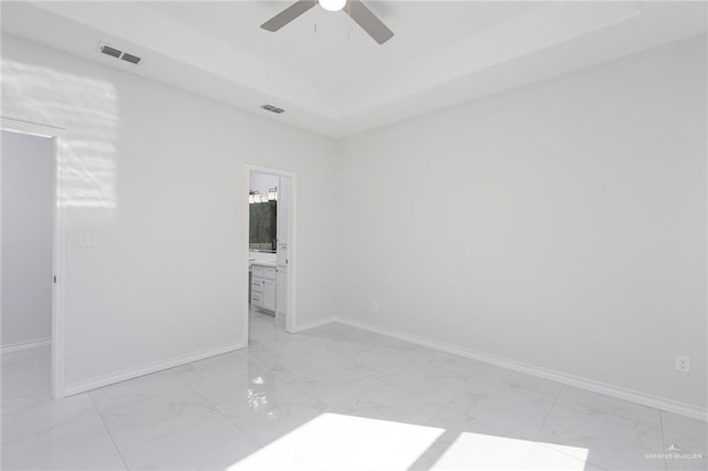 509 E Lorenzana St, Mercedes, TX 78570 - unfurnished room with baseboards, a ceiling fan, visible vents, a tray ceiling, and marble finish floor