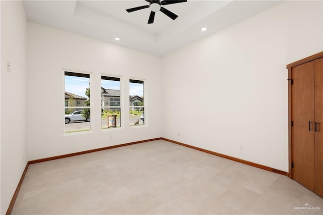 unfurnished room with a raised ceiling and ceiling fan