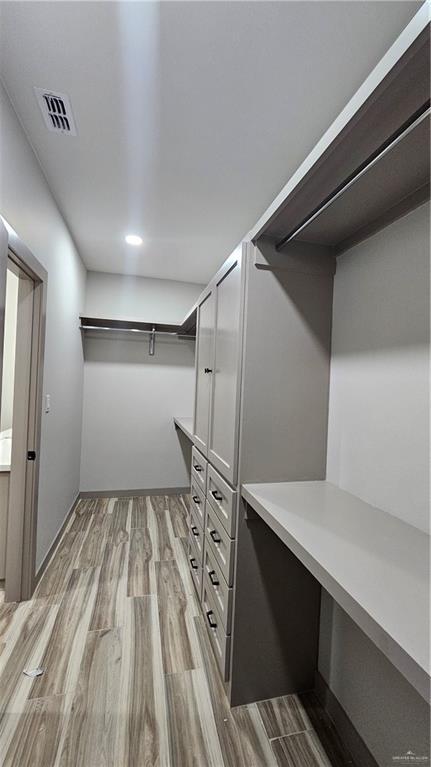 spacious closet with light wood-style flooring and visible vents